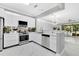 Open kitchen with stainless steel appliances, white cabinets, and sleek countertops at 7159 Cadiz Blvd, Orlando, FL 32819
