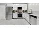 Well-lit modern kitchen featuring stainless steel appliances and white cabinets with marble flooring at 7159 Cadiz Blvd, Orlando, FL 32819