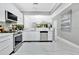 Modern kitchen with stainless steel appliances and white cabinets, open to dining area at 7159 Cadiz Blvd, Orlando, FL 32819