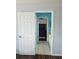 Hallway leading to the bathroom and bedroom featuring bright blue walls and tile flooring at 7187 Wild Strawberry Run, Winter Garden, FL 34787