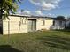 A quaint backyard features a sliding glass door and well-maintained lawn, perfect for outdoor activities at 7200 Ravenna Ave, Orlando, FL 32819