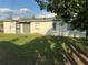 A backyard shows a sliding glass door, small potted plants, and spacious green lawn at 7200 Ravenna Ave, Orlando, FL 32819