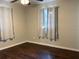 Neutral bedroom with hardwood floors, ample natural light, and white curtains at 7200 Ravenna Ave, Orlando, FL 32819