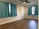 Spacious bedroom with hardwood floors, ample natural light, and light-blue curtains at 7200 Ravenna Ave, Orlando, FL 32819