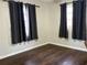 Bedroom with hardwood floors, ample natural light, and black-out curtains at 7200 Ravenna Ave, Orlando, FL 32819