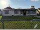 Charming single-story home with a red front door, tidy lawn, and a chain-linked fence at 7200 Ravenna Ave, Orlando, FL 32819