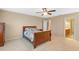 Bedroom with wooden furniture, carpeting, a ceiling fan and entry to the bathroom at 8137 Surf Bird St, Winter Garden, FL 34787