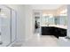 This luxurious bathroom showcases a glass shower, black vanity with dual sinks, and lots of space at 8390 Ludington Cir, Orlando, FL 32836