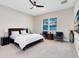 Bedroom with a large bed, seating, and natural light from the large window at 8390 Ludington Cir, Orlando, FL 32836