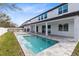 A pristine pool shimmers outside this home, complete with an outdoor patio and elegant architecture at 8390 Ludington Cir, Orlando, FL 32836