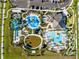 Aerial view of a luxurious resort-style community pool with water slides, play areas, and cabanas at 8824 Cruden Bay Ct, Davenport, FL 33896