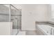 Bathroom featuring a glass-enclosed shower, soaking tub, tiled accents, and a bright, neutral color scheme at 8824 Cruden Bay Ct, Davenport, FL 33896