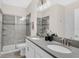 Modern bathroom with a glass-enclosed shower, double vanity, and sleek fixtures at 8824 Cruden Bay Ct, Davenport, FL 33896