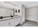 Well-lit bathroom with double sinks, white cabinets, mirrors, and a door to the toilet and shower at 8824 Cruden Bay Ct, Davenport, FL 33896