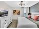 Modern bedroom with geometric accent wall, dresser, TV, and king-size bed with neutral bedding at 8824 Cruden Bay Ct, Davenport, FL 33896