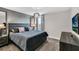 Bedroom featuring a gray accent wall, queen bed, nightstand, and decorative lighting at 8824 Cruden Bay Ct, Davenport, FL 33896