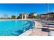 Community pool with plenty of seating and lounging areas under clear blue skies at 8824 Cruden Bay Ct, Davenport, FL 33896