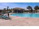 Community pool and bar, surrounded by chairs and palm trees, perfect for relaxation at 8824 Cruden Bay Ct, Davenport, FL 33896