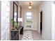 Elegant entryway with a modern console table, decorative mirror, stylish lighting, and a patterned rug at 8824 Cruden Bay Ct, Davenport, FL 33896