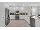 Modern kitchen featuring stainless steel appliances, white cabinetry, granite countertops, and a gray backsplash at 8824 Cruden Bay Ct, Davenport, FL 33896