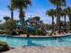 Inviting lazy river with a water slide and palm trees, providing a fun, resort-style experience at 8824 Cruden Bay Ct, Davenport, FL 33896