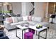 Bright living room features a gray leather couch, white marble-topped tables, and a patterned rug at 8824 Cruden Bay Ct, Davenport, FL 33896