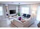 Stylish living room with a comfortable sectional sofa, a modern entertainment center, and plenty of natural light at 8824 Cruden Bay Ct, Davenport, FL 33896