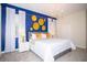 Bright main bedroom with a king-size bed, blue accent wall, and modern lighting fixtures at 8824 Cruden Bay Ct, Davenport, FL 33896