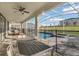 The covered patio features a dining set and lounge chairs overlooking the pool and landscaped backyard at 8824 Cruden Bay Ct, Davenport, FL 33896
