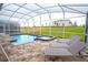Inviting outdoor pool and spa with screened enclosure and patio furniture for relaxation and leisure at 8824 Cruden Bay Ct, Davenport, FL 33896