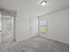 This bedroom features neutral carpeting, white walls, and an entry door at 907 Aspen View Cir, Groveland, FL 34736