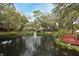 Scenic community pond with water feature, mature trees, lush landscaping, and a charming wooden deck at 940 Douglas Ave # 170, Altamonte Springs, FL 32714