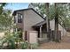 View of a two-story townhome with a gated entrance, surrounded by lush landscaping and mature trees at 940 Douglas Ave # 170, Altamonte Springs, FL 32714