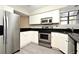 Modern kitchen with stainless steel appliances, white cabinets, and sleek black countertops at 940 Douglas Ave # 170, Altamonte Springs, FL 32714