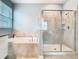 Bathroom featuring a tiled soaking tub and a glass-enclosed shower with tiled walls and neutral tones at 9542 Beautiful Way, Winter Garden, FL 34787