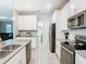 Contemporary kitchen features stainless steel appliances, light gray countertops, and white cabinets at 9542 Beautiful Way, Winter Garden, FL 34787