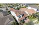 Aerial view of a home with a terracotta roof, palm trees, and colorful landscaping at 10209 Henbury St, Orlando, FL 32832