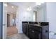 Bathroom with double vanity sink with granite countertops and black cabinets with views to the living area at 10209 Henbury St, Orlando, FL 32832