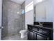 Modern bathroom featuring a glass shower, tile, and dark vanity with granite countertop at 10209 Henbury St, Orlando, FL 32832