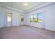 Bright bedroom with large windows, tray ceiling, and neutral carpet at 10209 Henbury St, Orlando, FL 32832