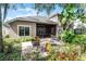 Exterior view of the backyard featuring a paver patio with seating and lush landscaping at 1203 Gatwick Loop, Lake Mary, FL 32746