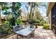 Paver patio in backyard with seating, dining area, grill, and tropical landscaping at 1203 Gatwick Loop, Lake Mary, FL 32746