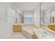 Bright bathroom featuring a soaking tub, vanity, and large mirror at 1203 Gatwick Loop, Lake Mary, FL 32746