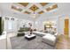 Open-concept living room features modern decor, coffered ceilings and views into dining room and kitchen at 1203 Gatwick Loop, Lake Mary, FL 32746