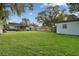 Spacious backyard with a shed, wooden fence, green grass, and a covered patio at 125 E Grant St, Orlando, FL 32806