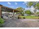 Large brick patio area features a pergola, comfortable egg chair, seating area, and open green grass at 125 E Grant St, Orlando, FL 32806