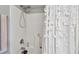 Bathroom shower featuring a shower head, faucet, and a decorative white shower curtain with unique designs at 125 E Grant St, Orlando, FL 32806