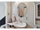 Bathroom with unique oval mirror, cabinet, and pedestal sink with pink soap dispenser at 125 E Grant St, Orlando, FL 32806