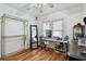 Sunlit bedroom with wood floors, two windows, shelving and closet organizer perfect for storage and organization at 125 E Grant St, Orlando, FL 32806