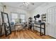 Bright bedroom features hardwood floors, ceiling fan, and dual desks, perfect for a home office or creative space at 125 E Grant St, Orlando, FL 32806
